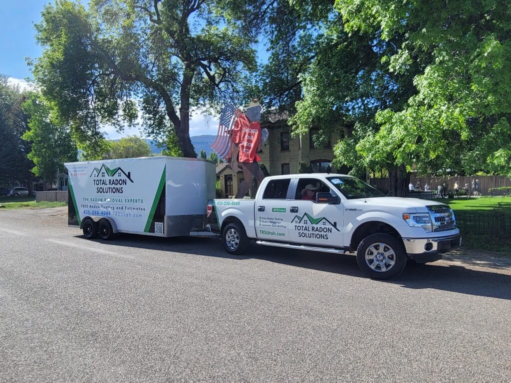 Total Radon Solutions branded pickup truck and trailer participating in the Scandinavian Days parade in Ephraim, Utah